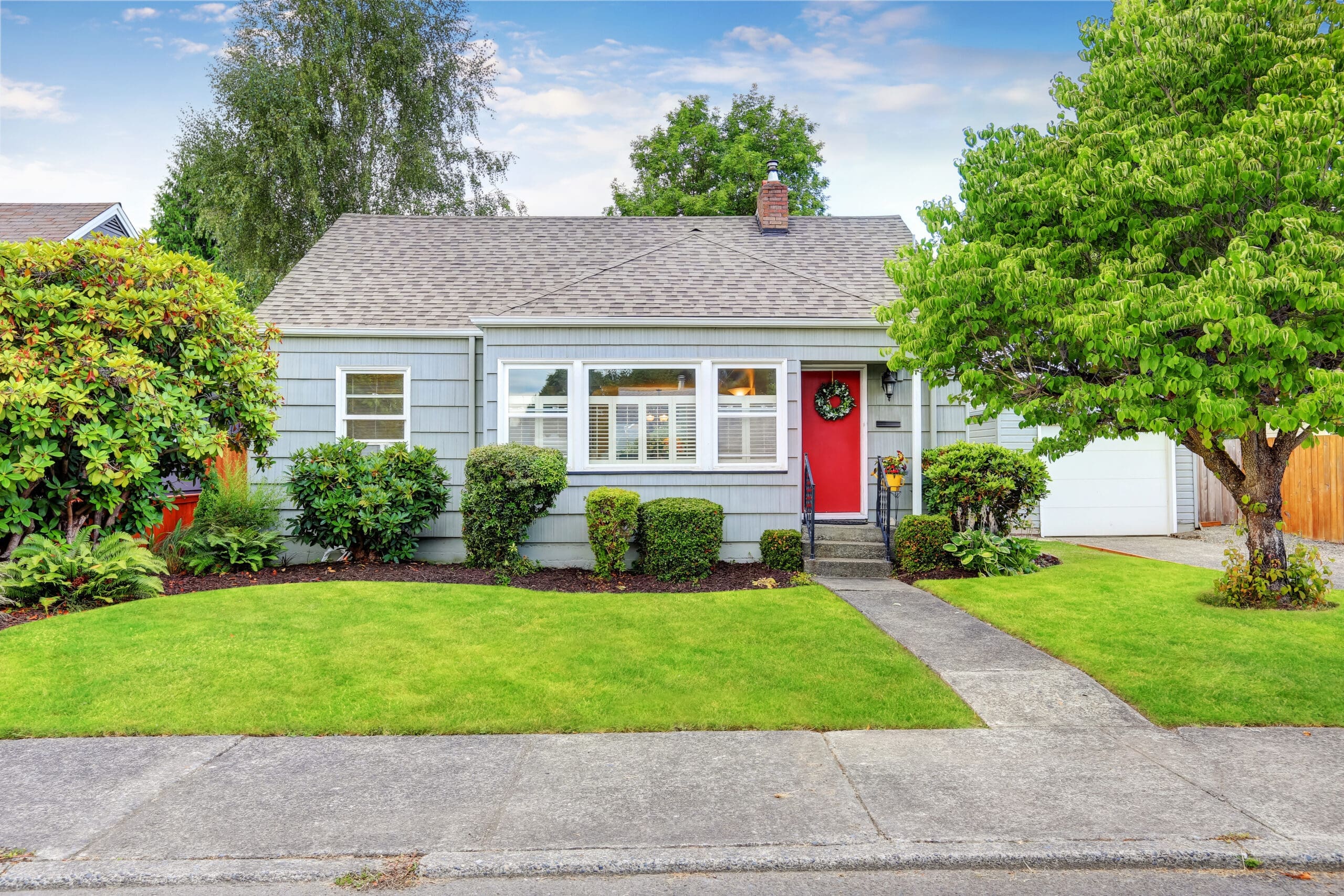 Exterior of small American house with blue paint Exterior of small American house with blue paint and red entrance door. Northwest, USA